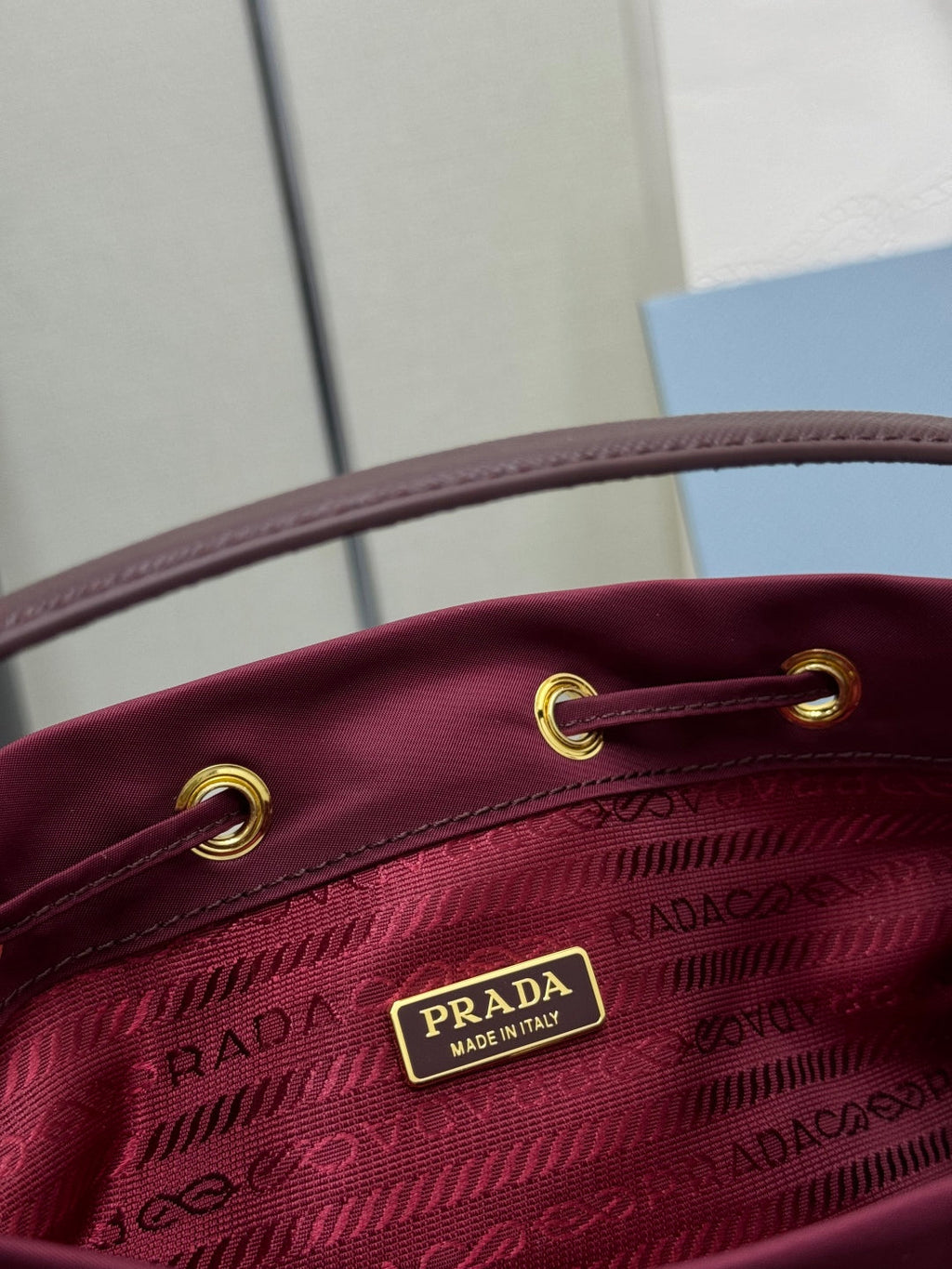 PRADA 25S DUET BUCKET BAG 23 IN BURGUNDY RE-NYLON GOLD HARDWRE